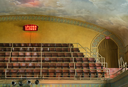 Louder, Slower neon sign used during degree performances on rear wall of auditorium